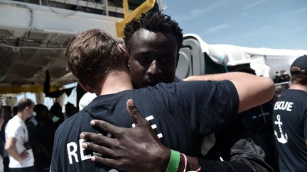 Un homme sauvé par le bateau humanitaire "l'Aquarius" enlace un membre de l'équipage, après avoir débarqué dans le port de Valence, en Espagne, le 17 juin 2018. (KARPOV / SOS MEDITERRANEE / AFP)