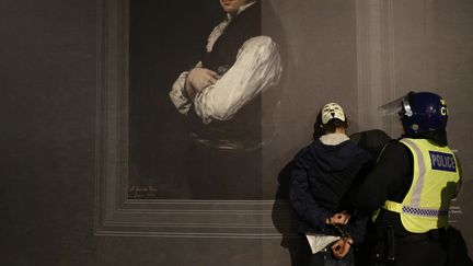 Au total, 50 militants ont été arrêtés par la police londonnienne, comme cet homme menotté devant la National Gallery. (PETER NICHOLLS / REUTERS)