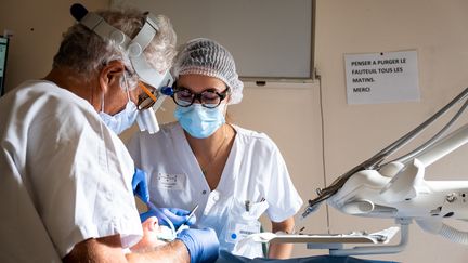 Un chirurgien-dentiste et son assistante lors d'un rendez-vous à Toulouse, le 30 septembre 2021. (ADRIEN NOWAK / HANS LUCAS / AFP)