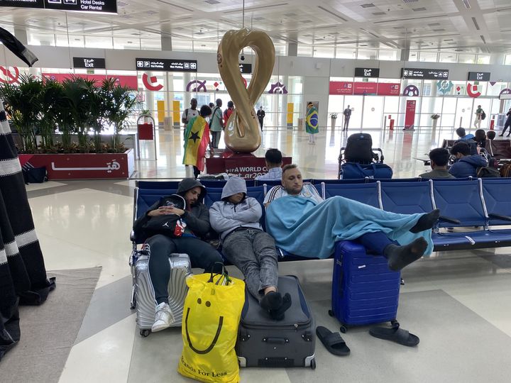 Des supporters somnolent dans le hall de l'aéroport international de Doha (Qatar), le 2 décembre 2022. (RAPHAEL GODET / FRANCEINFO)