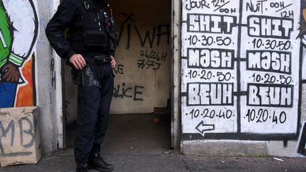 Un policier devant un point de deal à Marseille, le 11 décembre 2023. (NICOLAS TUCAT / AFP)