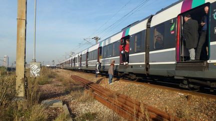 Des personnes descendant d'un RER arrêté entre le Stade de France et la gare du Nord à Paris, le 7 décembre 2016. (STR / AFP)