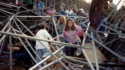 Des spectateurs s'extraient des d&eacute;combres de la tribune de Furiani, &agrave; Bastia, le 5 mai 1992. (ERIC CABANIS / AFP)