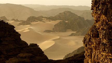 Ce haut plateau aride constitué de grès, couches superposées de vase et de sable solidifiés issues des mers qui couvraient la totalité du plus grand désert du monde, se trouve à plus de 1.000 mètres d'altitude et s'étend sur 50 à 60 km d'est en ouest et 800 km du nord au sud, soit une superficie de près de 120.000 km2. Sur cette photo, des colonnes de grès, formation volcanique et reg (désert de pierre) de l'Erg Admer, près de Djanet, dans le massif du Tassili N' Ajjer (PHILIPPE ROY / Aurimages )