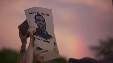 Un manifestant brandit un portrait de George Floyd lors d'une manifestation, à Minneapolis (Minnesota, Etats-Unis), le 27 mai 2020. (CHRISTINE T. NGUYEN / AP / SIPA)