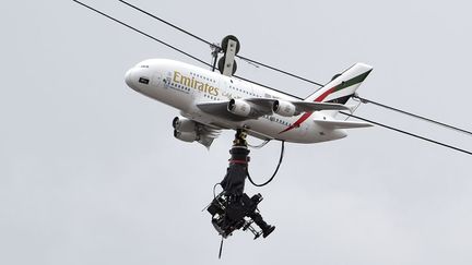 Une cam&eacute;ra est accroch&eacute;e &agrave; une maquette d'avion aux couleurs de la compagnie Emirates airlines au-dessus de Roland-Garros &agrave; Paris, le 25 mai 2014. (DOMINIQUE FAGET / AFP)