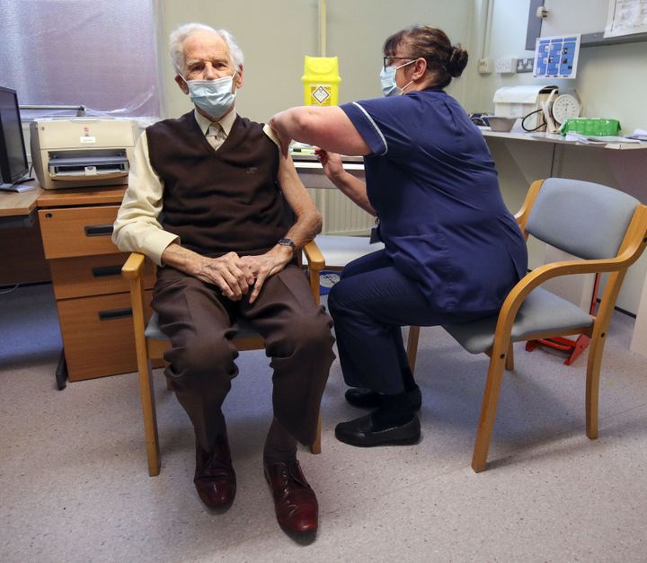 Un homme reçoit une dose de vaccin contre le coronavirus, le 14 décembre 2020, à Londres, au Royaume-Uni. (STEVE PARSONS / AFP)