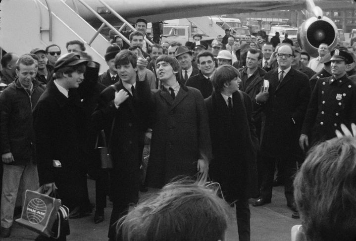 John Lennon, Paul McCartney, George Harrison et Ringo Starr à l'aéroport JFK de New York (États-Unis) en février 1964, dans le documentaire "Beatles 64" de David Tedeschi diffusé sur la plateforme Disney+. (DISNEY+ / APPLE CORPS, LTD)