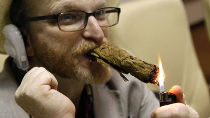 Un homme allume le cigare qu'il a lui m&ecirc;me confectionn&eacute; lors d'un atelier au festival del Habano &agrave; La Havane (Cuba), le 29 f&eacute;vrier 2012. (ALEJANDRO ERNESTO / EPA / MAXPPP)