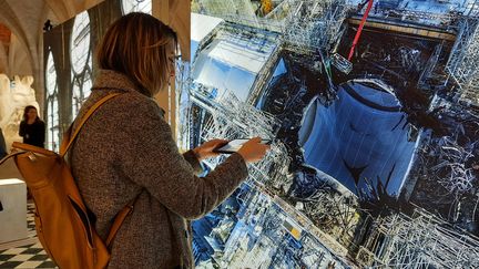 Le visiteur de "Notre-Dame de Paris, l’exposition augmentée" au Collège des Bernardins à Paris dispose d'une tablette appelée Histopad, avec laquelle il sélectionne les contenus qui l'intéresse.  (ANNE CHEPEAU / RADIO FRANCE)