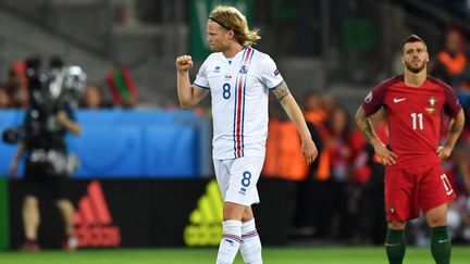 L'Islandais Birkir Bjarnason célèbre son but le poing fermé, sous le regard de Vieirinha, le 14 juin 2016, au stade Geoffroy Guichard de Saint-Etienne. (UWE ANSPACH / DPA / AFP)