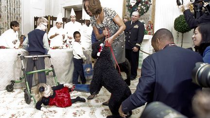 La First Lady Michelle Obama r&eacute;agit &agrave; la chute d'une petite fille bouscul&eacute;e par le nouveau chien de la famille Obama lors des pr&eacute;sentations des d&eacute;corations de No&euml;l de la Maison Blanche &agrave; Washington (Etats-Unis), le 4 d&eacute;cembre 2013. (JASON REED / REUTERS)