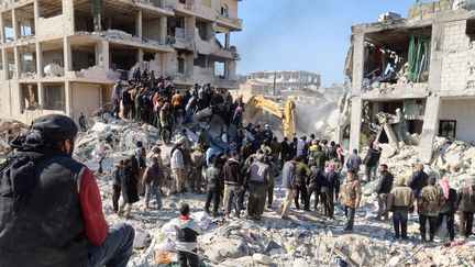 Des secouristes et des rescapés recherchent des survivants dans les décombres d'un bâtiment à Jindayris (Syrie), le 9 février 2023. (MOHAMMED AL-RIFAI / AFP)