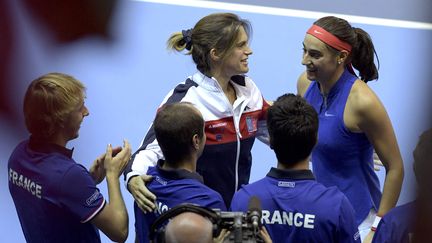 Caroline Garcia célèbre sa victoire en Fed Cup contre la République tchèque, aux côtés de la sélectionneuse Amélie Mauresmo, le 13 novembre 2016. (PATRICK HERTZOG / AFP)