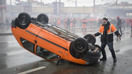 La photo de cette voiture, retourn&eacute;e et br&ucirc;l&eacute;e le 6 novembre 2014 &agrave; Bruxelles lors d'une manifestation anti-aust&eacute;rit&eacute;, a fait le tour des m&eacute;dias belges. (LAURIE DIEFFEMBACQ / BELGA MAG / AFP)