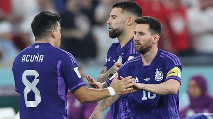 Les Argentins Marcos Acuna et Lionel Messi face à la Pologne, le 30 novembre 2022 à Doha. (GIUSEPPE CACACE / AFP)