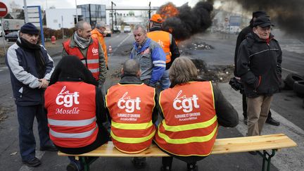 Des salari&eacute;s de l'acierie ArcelorMittal de Florange (Moselle) bloquent l'entr&eacute;e du site, le 8 mars 2012. (JEAN-CHRISTOPHE VERHAEGEN / AFP)