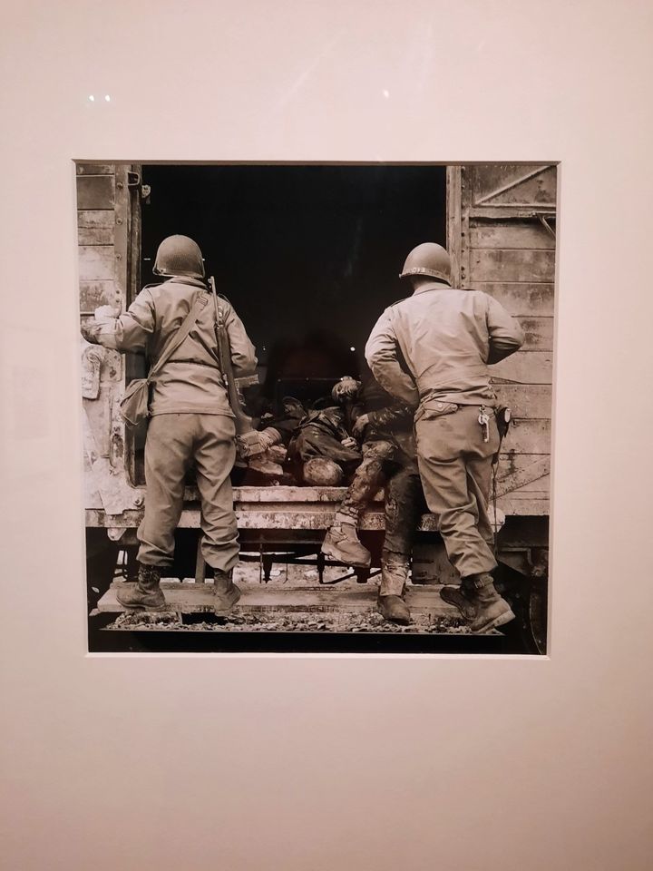 Une photo prise par Lee Miller à Dachau en 1945 : des soldats américains devant un wagon avec des cadavres de prisonniers. Elle fait partie de l’exposition "Femmes photographes de guerre" au&nbsp;Musée de la Libération à Paris. (ANNE CHÉPEAU / FRANCE-INFO)