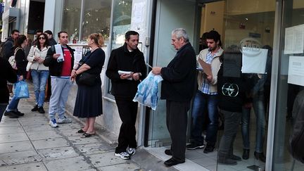 Des Grecs devant une agence pour l'emploi Manpower &agrave; Ath&egrave;nes (Gr&egrave;ce), le 8 octobre 2013. (LOUISA GOULIAMAKI / AFP)