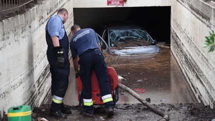 Des agents s'activent pour pomper l'eau d'un parking souterrain, le 5 octobre 2015 &agrave; Mandelieu-la-Napoule (Alpes-Maritimes). (ANNE-CHRISTINE POUJOULAT / AFP)