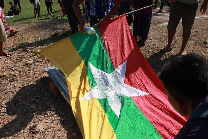 Cette photo de Kawkareik Open News prise le 8 avril 2021 et rendue publique à l'AFP le 9 avril 2021 montre des manifestants versant de l'essence sur le drapeau du Myanmar pour le brûler avec des copies de la constitution de 2008 lors d'une manifestation contre le coup d'État militaire dans le canton de Kawkareik à Karen au Myanmar Etat. (HANDOUT / KAWKAREIK OPEN NEWS / AFP)