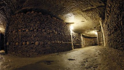 Des cr&acirc;nes et des ossements empil&eacute;s dans les catacombes de Paris, le 14 octobre 2014. (PATRICK KOVARIK / AFP)