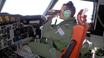 Un militaire australien recherche le&nbsp;Boeing disparu de la Malaysia Airlines dans l'oc&eacute;an Indien,&nbsp;le 17 mars 2014. (ROYAL AUSTRALIAN AIR FORCE / AFP)