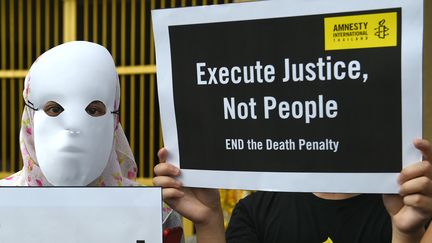 Des activistes d'Amnesty International protestent devant une prison près de Bangkok&nbsp;(Thaïlande), le 19 juin 2018, contre l'exécution programmée&nbsp;d'un jeune homme de 26 ans. (ROMEO GACAD / AFP)