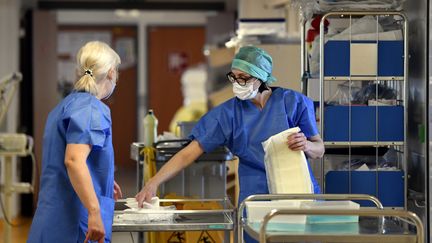 Du personnel médical dans un couloir menant aux chambres des patients atteints de Covid-19 au CHRU de Nancy&nbsp;le 19 mars 2020.&nbsp;Le CHRU de Nancy a activé son Plan Blanc le 15 mars dernier pour mettre en place des mesures d'organisation exceptionnelles. (ALEXANDRE MARCHI / MAXPPP)