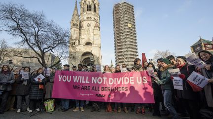 Des Berlinois montrent une banderole où il est écrit, en anglais, "Vous nous diviserez pas, nous sommes tous Berlinois", mercredi 21 décembre à Berlin. (CLEMENS BILAN / AFP)