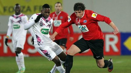 L'avant-centre de L'Ile Rousse, Benjamin Santelli (&agrave; dr.) &agrave; la lutte avec le Girondin Andr&eacute;&nbsp;Biyogo (&agrave; g.), en 16e de finale de la Coupe de France, le 22 janvier 2014. (PASCAL POCHARD-CASABIANCA / AFP)