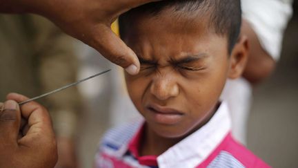 Un jeune musulman se fait appliquer du crayon kh&ocirc;l &agrave; l'occasion des c&eacute;l&eacute;brations de l'A&iuml;d-el-K&eacute;bir &agrave; Bombay (Inde), le 16 octobre 2013. (RAFIQ MAQBOOL / AP / SIPA)