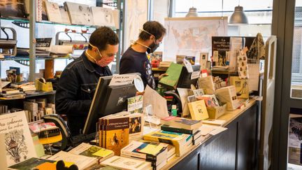 Les employés&nbsp;d'une librairie de Besançon respectent les mesures saniraires alors que l'établissement a rouvert partiellement en proposant la réservation en ligne, le 29 avril 2020. (JEAN-FRANÇOIS FERNANDEZ / FRANCE-BLEU BESANÇON)