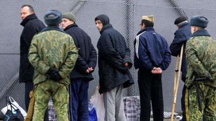 Minsk, en Biélorussie : prisonniers gardés par des soldats.

 (AFP PHOTO / VIKTOR DRACHEV)