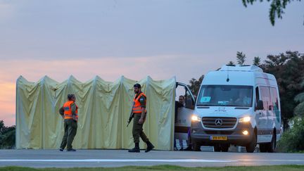 Des membres des forces de sécurité israéliennes positionnés à côté d'une ambulance alors que le personnel médical se prépare à l'arrivée des otages israéliens qui devaient être libérés par le Hamas, le 25 novembre 2023, dans le district de Tel-Aviv. (JACK GUEZ / AFP)