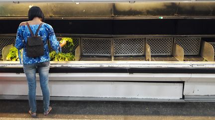 Une Vénézuélienne fait ses courses dans un hypermarché aux rayons vides, le 11 janvier 2018 à Caracas (Venezuela). (JUAN BARRETO / AFP)