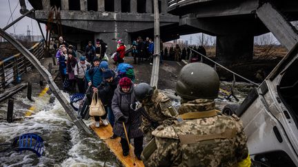 Des réfugiés fuient la ville d'Irpin, au nord-ouest de Kiev (Ukraine), le 7 mars 2022.&nbsp; (DIMITAR DILKOFF / AFP)