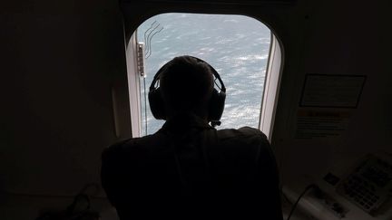 Un&nbsp;membre de la marine américaine survole une zone de l'océan Atlantique, à la recherche du sous-marin argentin disparu San Juan, le 22 novembre 2017.&nbsp; (STRINGER / REUTERS)