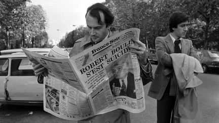 Un homme lit le journal "France Soir", à Paris, le 30 octobre 1979, jour de l'annonce de la mort de Robert Boulin. (GEORGES BENDRIHEM / AFP)