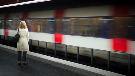 Une femme attend le RER à la station Auber à Paris, le 23 mars 2010. (MARTIN BUREAU / AFP)