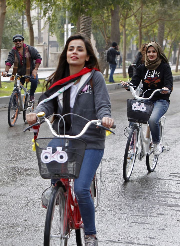 L'artiste cycliste irakienne, Marina Jaber, sur son désormais fameux vélo rouge, entre la rue Abou Nawas et le pont suspendu dans le quartier commerçant de Karrada, pour une manifestation contre le conservatisme et pour la paix, le 5 décembre 2016, à Bagdad. (SABAH ARAR/AFP)