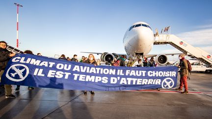 Des associations environnementales organisent une action pour dénoncer l'impact de l'aviation sur le climat, à l'aéroport Roissy-Charles-de-Gaulle, près de Paris, le 3 octobre 2020. (JULIEN HELAINE / HANS LUCAS / AFP)