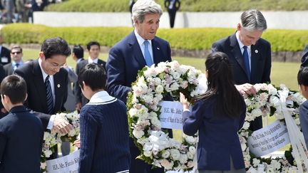 Le secrétaire d'Etat américain John Kerry (au centre), le ministre des Affaires étrangères japonais Fumio Kishida (à g.) et le ministre des Affaires étrangères britannique&nbsp;Philip Hammond (à dr.) au mémorial de la Paix, à Hiroshima (Japon), le 11 avril 2016. (KAZUHIRO NOGI / POOL)