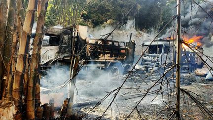 Des véhicules incendiés sur une route de Hpruso, dans l'Etat de Kayah (Birmanie), le 24 décembre 2021. (KARENNI NATIONALITIES DEFENSE FORCE / AP)