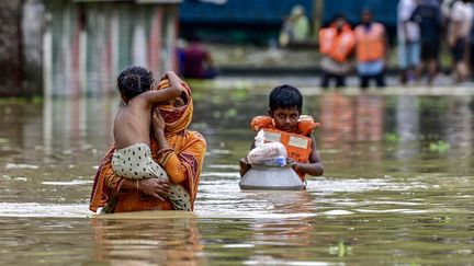 Feni residents in a flooded street on August 24, 2024 in Bangladesh. (MUNIR UZ ZAMAN / AFP)