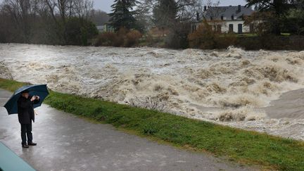 Un passant se protège de la pluie à Nay (Pyrénées-Atlantiques), le 10 janvier 2022. (MAXPPP)