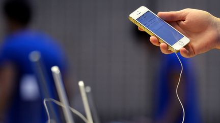 Un employ&eacute; d'Apple met en place des iPhone dans une boutique de Londres (Royaume-Uni), le 20 septembre 2013. (BEN STANSALL / AFP)