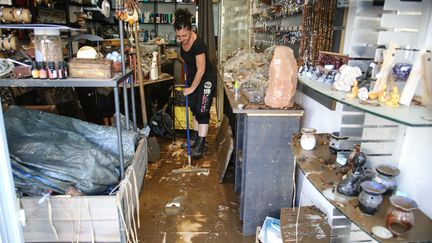 Une commerçante nettoie son magasin, à Ajaccio (Corse-du-Sud), après les intempéries, le 12 juin 2020. (PASCAL POCHARD-CASABIANCA / AFP)