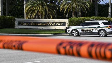 Une voiture de police stationne devant l'entrée du club de golf de Donald Trump, le 15 septembre 2024 en Floride (Etats-Unis). Des coups de feu ont été tirés dans la zone dimanche. (CHANDAN KHANNA / AFP)