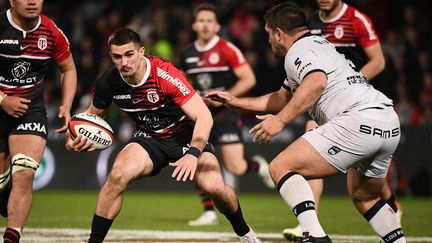 Thomas Ramos (Stade Toulousain), pris en tenaille par la défense de Lyon, lors de la 21e journée du Top 14, le 27 mars 2022 au Stade Ernest-Wallon (VALENTINE CHAPUIS / AFP)